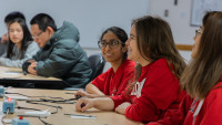 Students at a table, engaged in a Science Bowl competition with electronic buzzers on the tables.